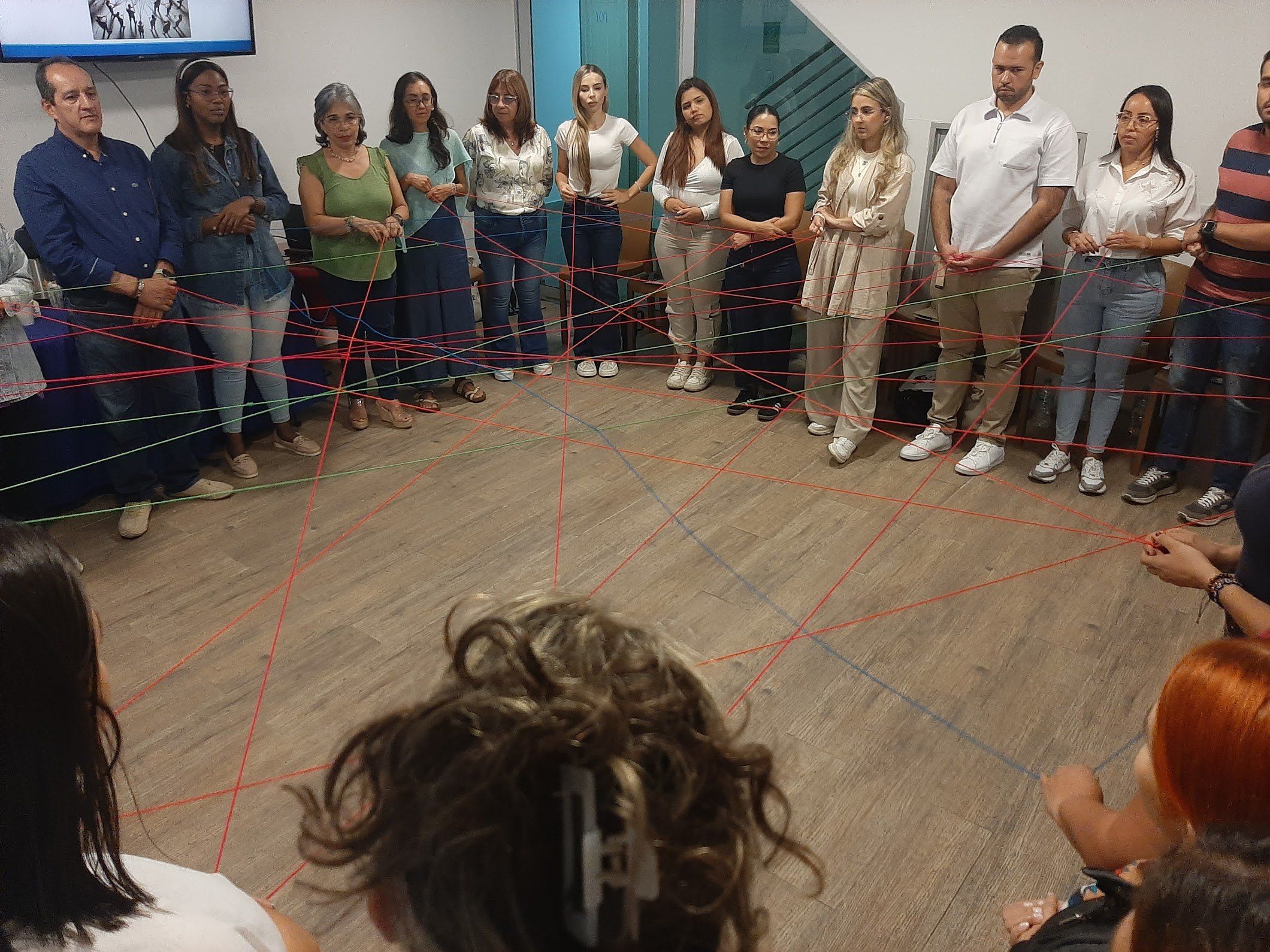 Ejercicio sistémico con hilos rojos que conectan a los participantes de pie en círculo
